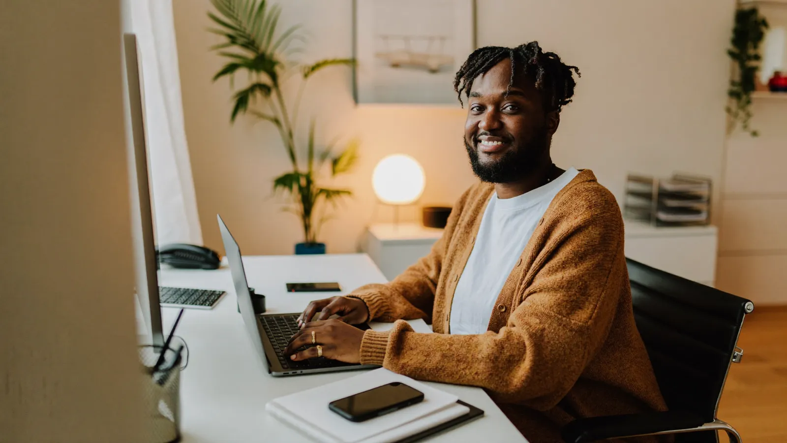 Ondernemer vergelijkt zakelijke software op een laptop in een warm thuiskantoor